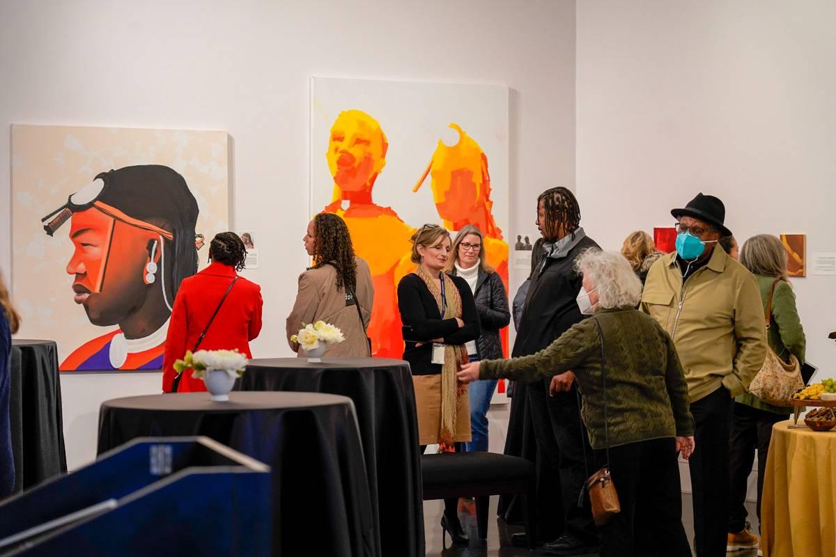 A group of people stand in the TCC art gallery 